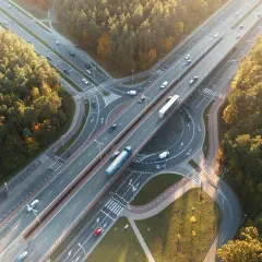 Widok z lotu ptaka na węzeł autostradowy otoczony lasem jesienią.