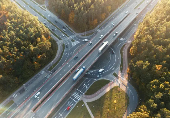 Widok z lotu ptaka na węzeł autostradowy otoczony lasem jesienią.