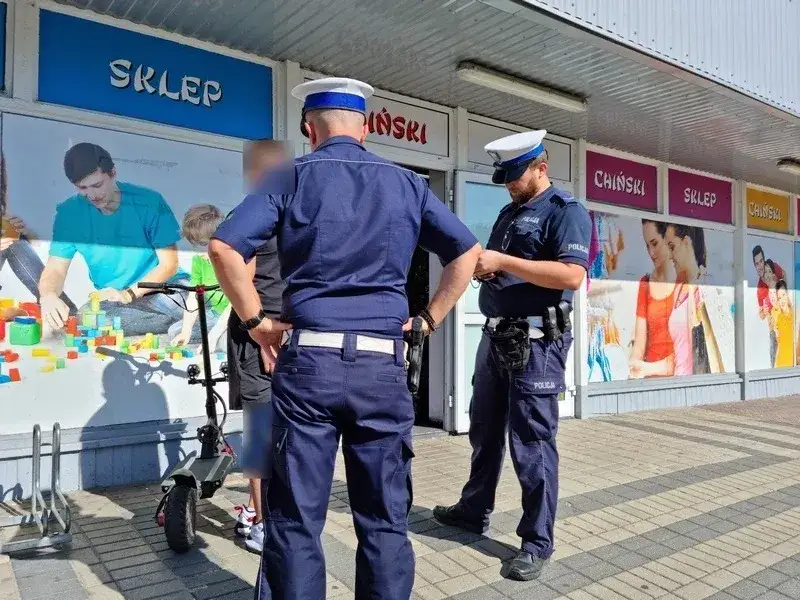 policjant wystawia mandat kierowcy hulajnogi elektrycznej