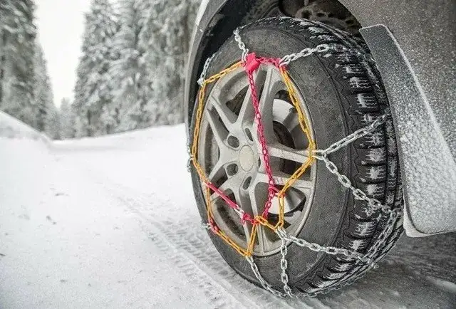 Samochód z łańcuchami śniegowymi na oponach w górach
